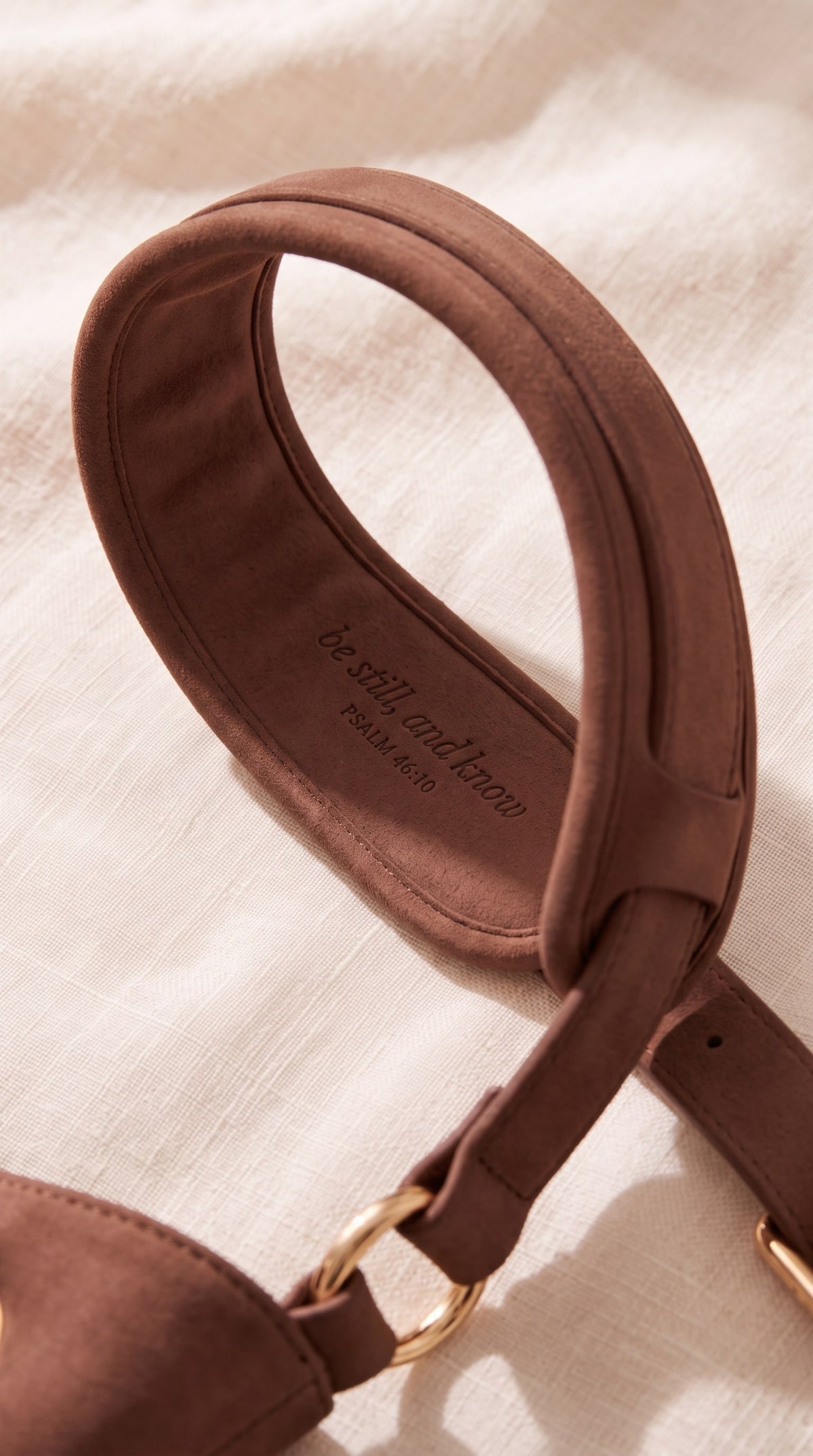 Brown shoulder strap with 'be still, and know', Psalm 46:10, debossed inside