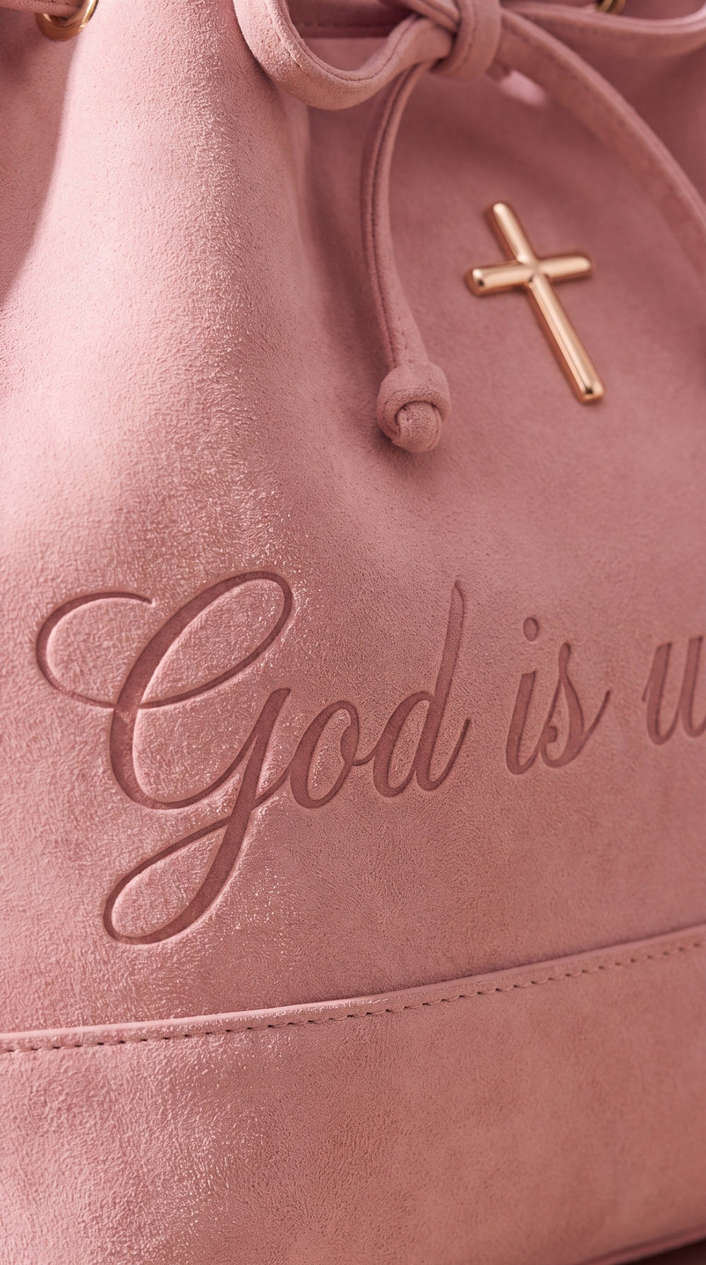 God is within her debossed on pink suede below a rose-gold cross